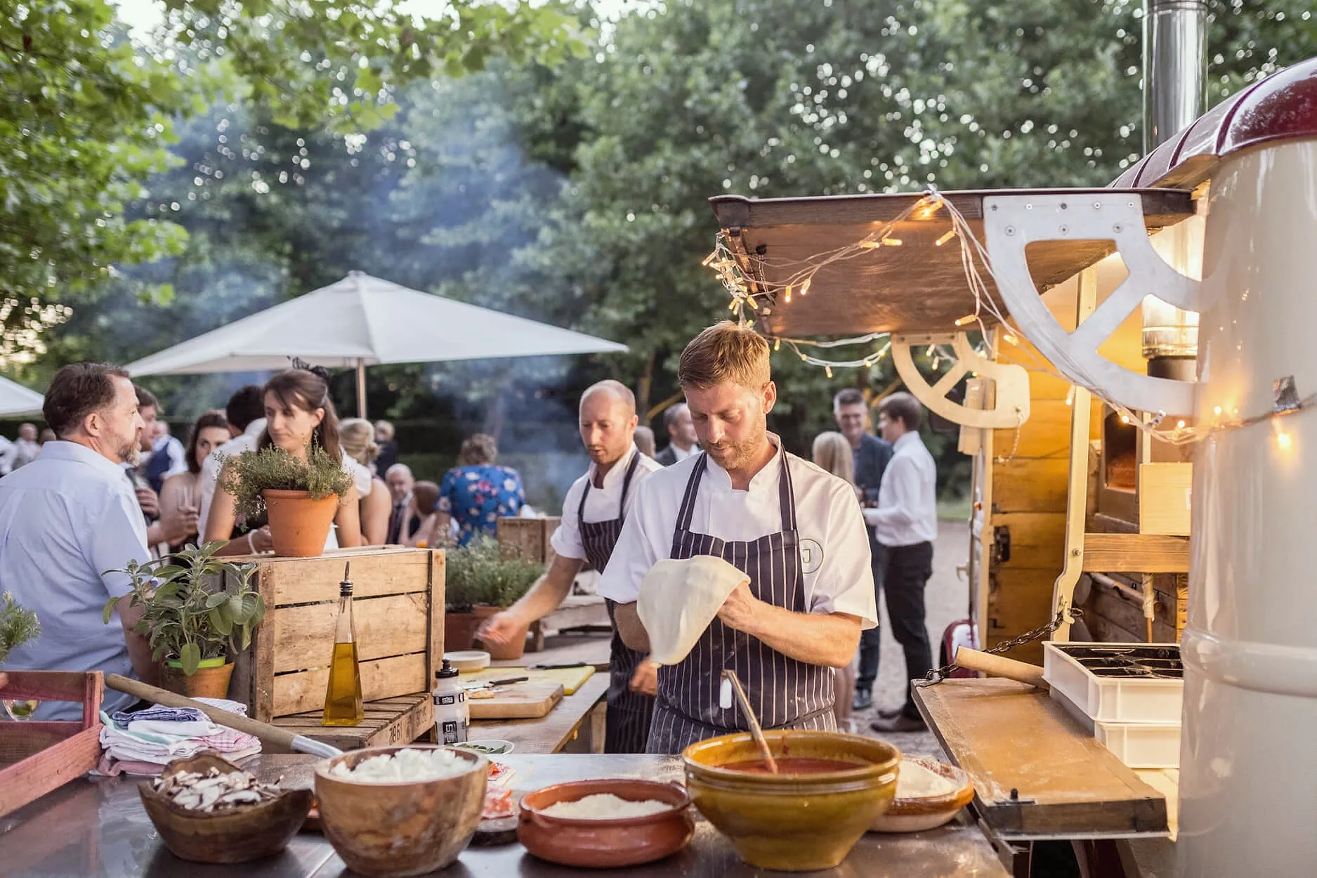 Chefs cooking for guests at an outdoor kitchen in the courtyard