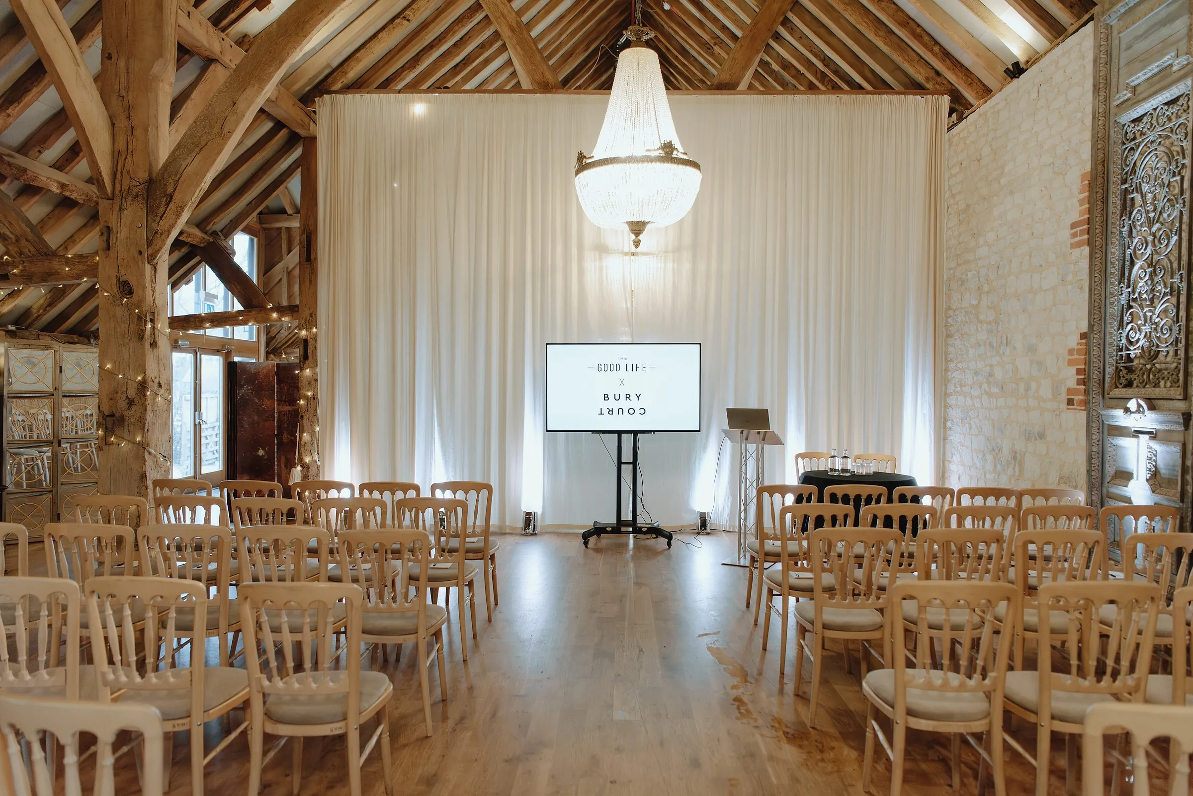 The barn set for a presentation with rows of chairs, a lectern and a screen in front of white drapes