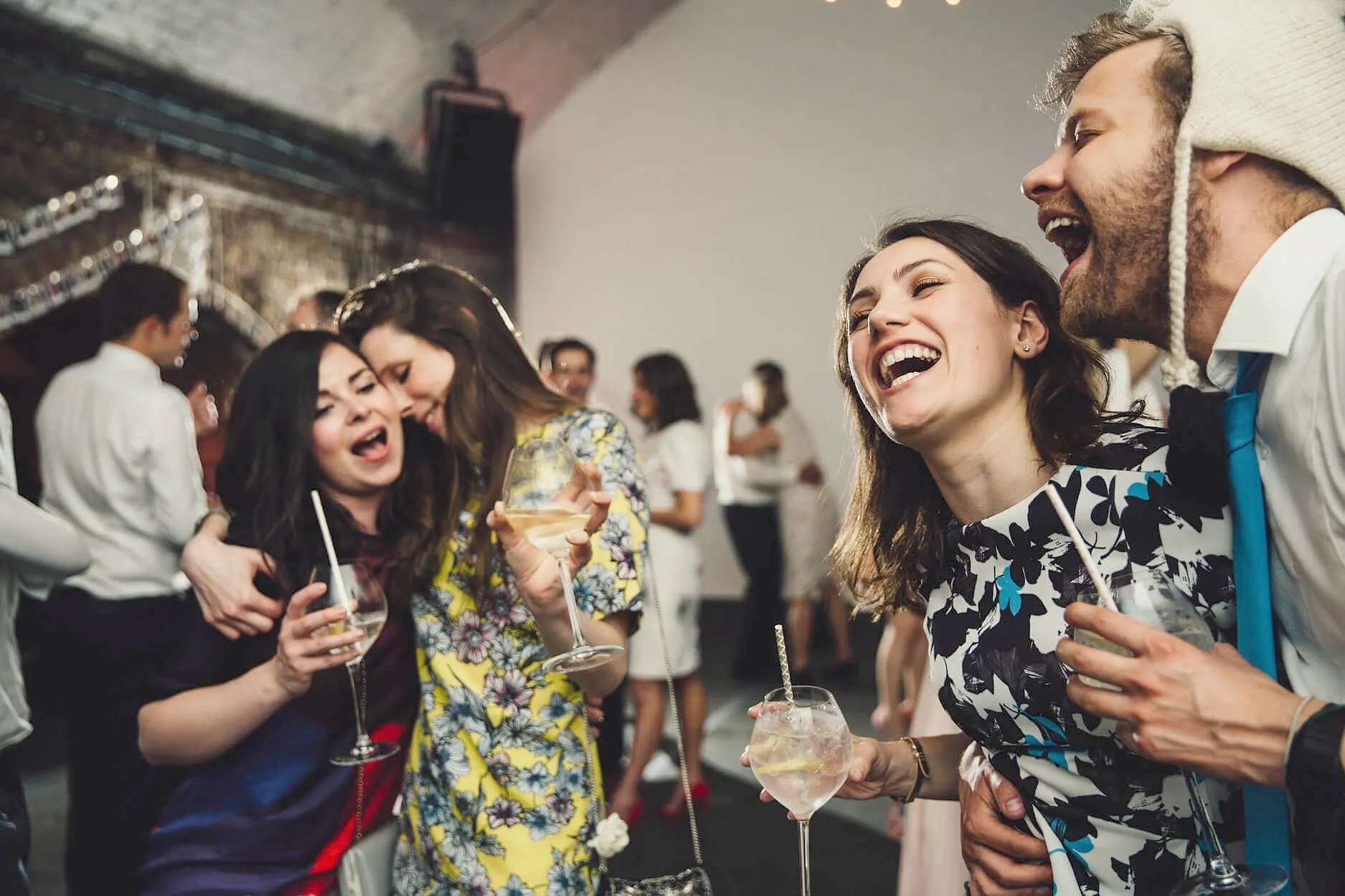 Friends laughing together with drinks at a party