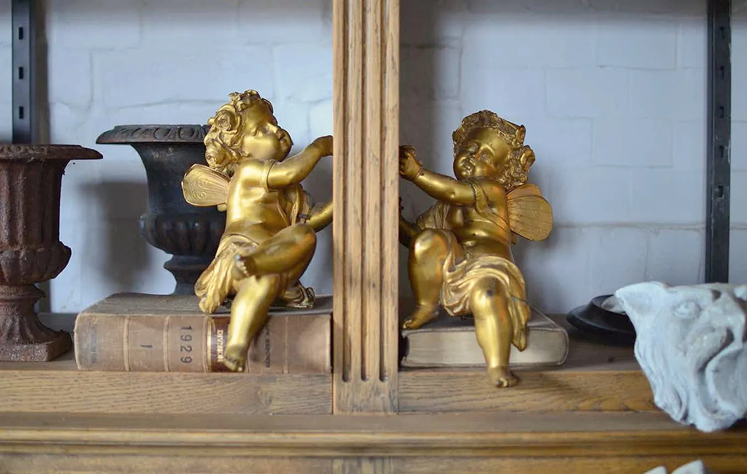 Gilded cherubs and old books on a shop shelf